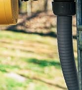 Camper hooking up their Camco RV power cord to the campground power pedestal