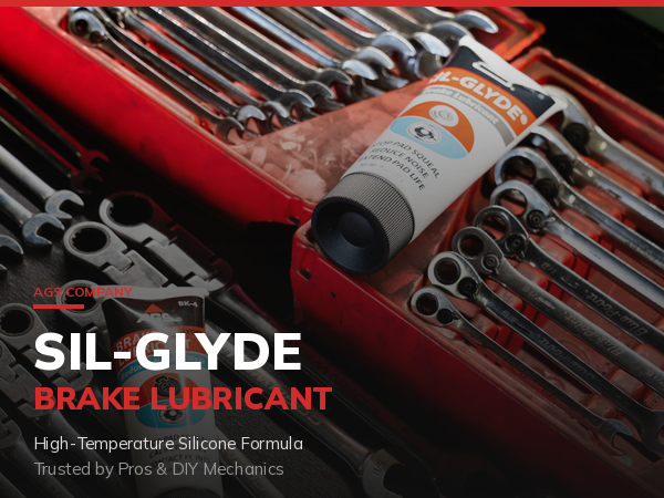 Sil-Glyde brake lubricant tube on a garage workbench with professional tools in the background