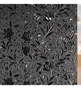 Abstract black and gray pattern featuring repeated floral or foliage motifs in a dense, decorative arrangement.