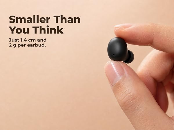A tiny black wireless earbud held between two fingers, showing how small it is