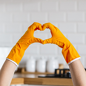 hands making a heart sign over a clean kitchen