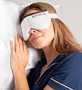 Woman relaxing in bed while wearing an Avenova heat therapy mask.