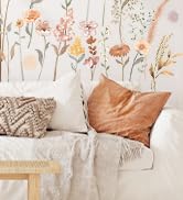 Decorative interior scene showing pastel-colored bedding and pillows arranged on a bed with floral patterns and soft textures.