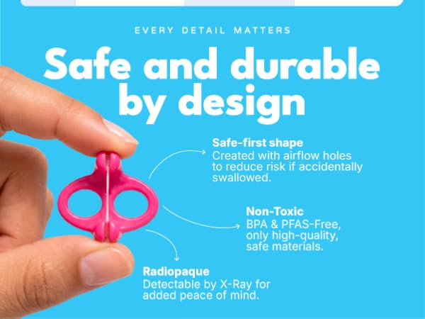 Hand holding pink Gfloss dental flosser showing safe-first ergonomic design with airflow holes