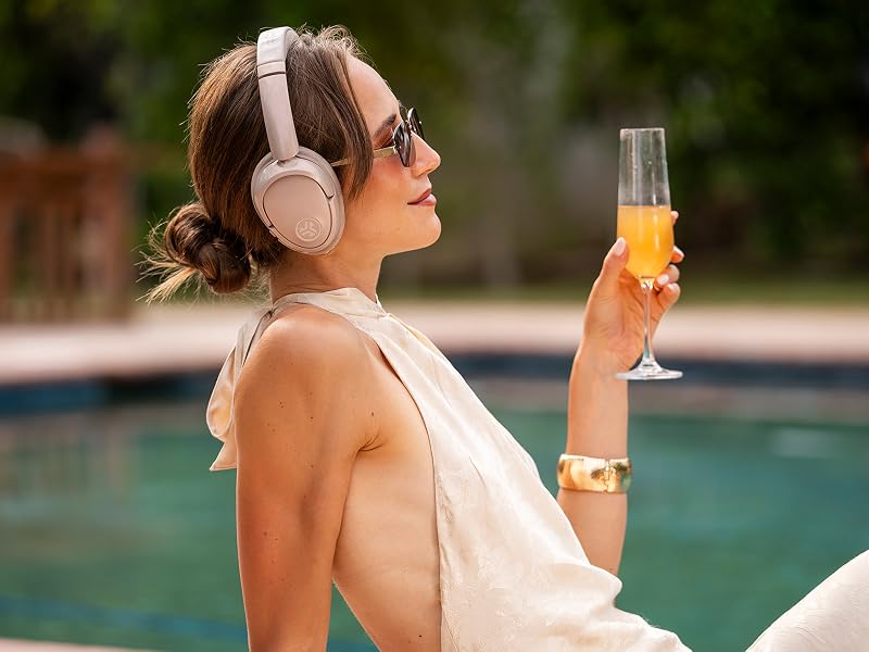 A woman wearing lux headphones by the pool while relaxing