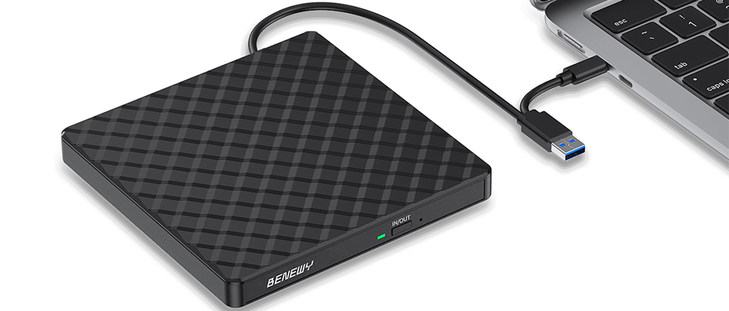 Black quilted external hard drive with USB-C cable connection to laptop, portable storage device for data backup and file transfer.