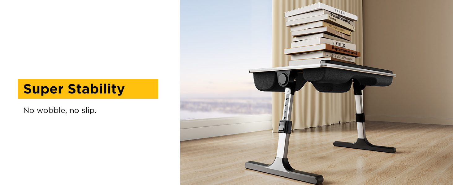 Stable adjustable lap desk shown holding heavy stack of books on hardwood floor.