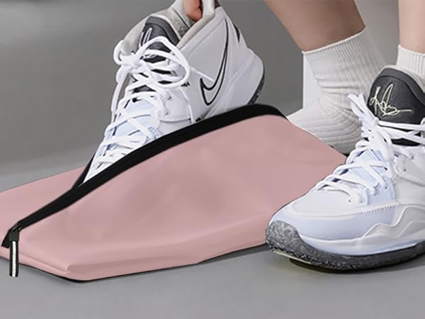 White Nike basketball shoes with gray soles, worn by a person. A pink yoga mat or exercise mat is visible in the foreground.