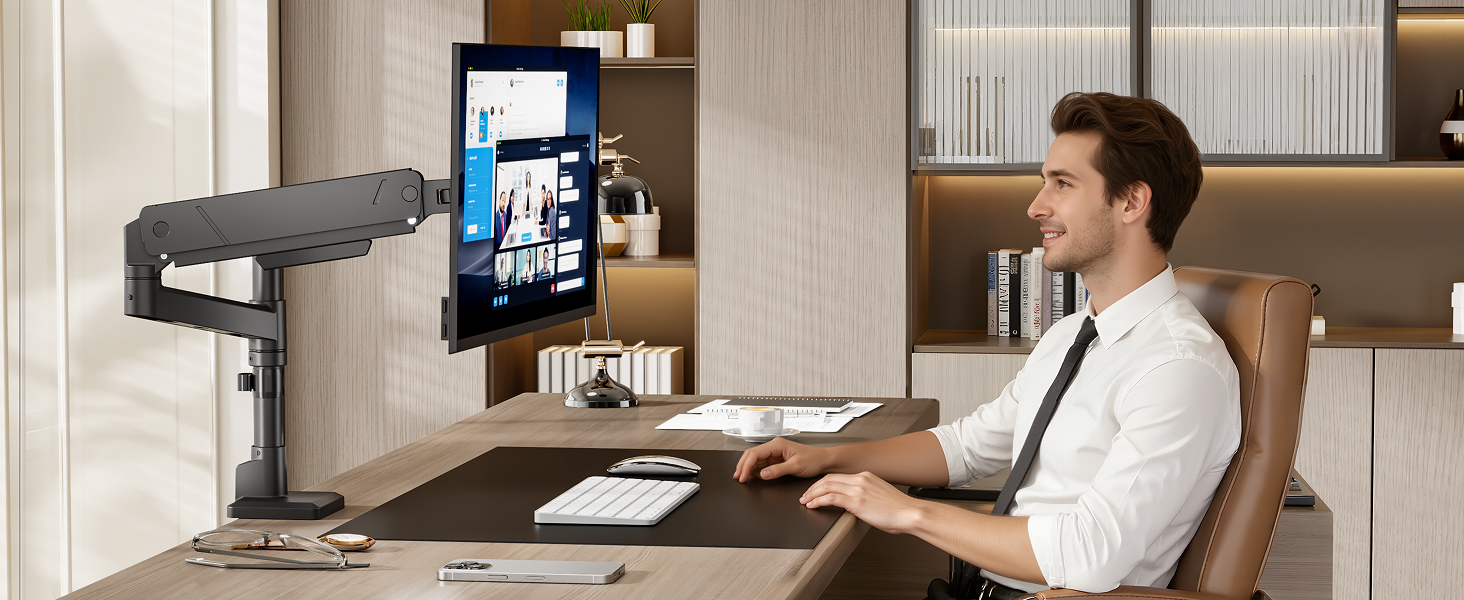 Man seated at desk in office setting, using tablet mounted on black articulating desk stand with screen displaying application interface.
