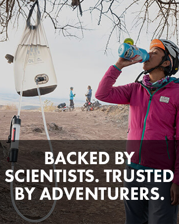 Woman drinking water next to a filter system
