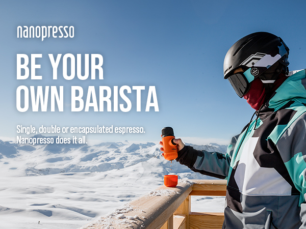 Nanopresso portable espresso maker advertised in snowy mountain setting. Person in ski gear preparing coffee on wooden surface.