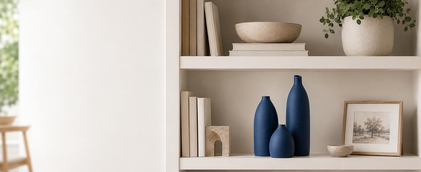 Deep navy ceramic vases styled on a neutral bookshelf with modern home decor.