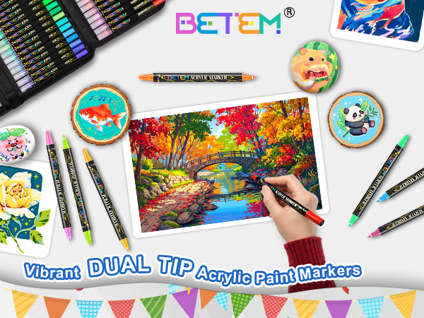 Text reads 'BETEM DUAL TIP Acrylic Paint Markers'. Marketing display showing colorful art markers with decorative bunting and artwork samples demonstrating marker usage.