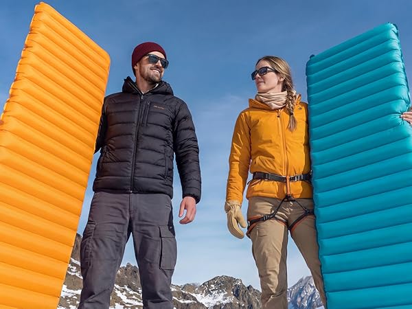 Couple holds Airlive2000 pads at mountain camp, ready to rest.