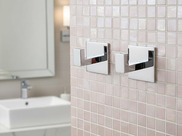 Multiple views of modern bathroom wall-mounted accessories in chrome finish against pink tile backdrop, showing installation progression.