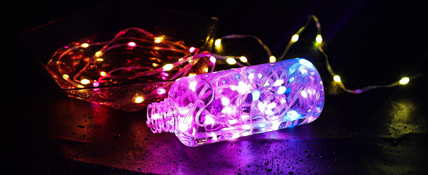 Colorful LED string lights in glass bottles, displaying red, blue, and purple illumination against a dark background.