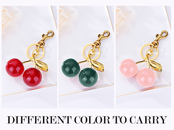 Cherry-shaped keychains in three colors: red, green, and pink. Gold-toned metal with glossy, round gemstone cherries and leaf accent.