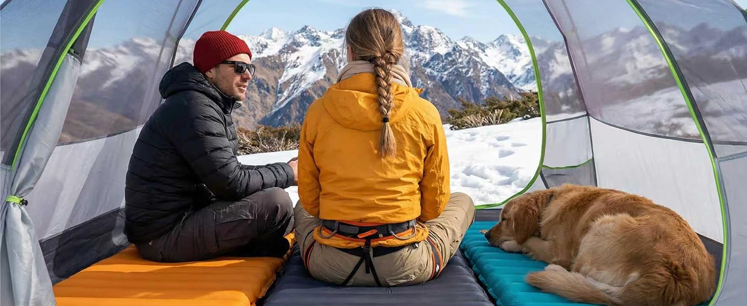 Couple and dog resting in tent on Airlive2000 pads with mountain view.