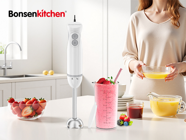 Kitchen scene with immersion blender being used to make colorful smoothies. Bonsenkitchen brand visible on blender. Various fruits and smoothie bowls on counter.