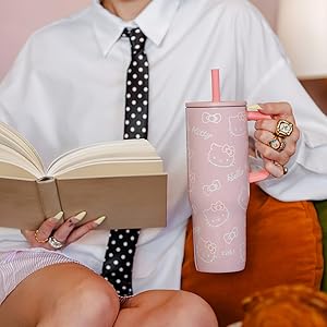 Hello Kitty stainless steel straw tumbler held by woman reading book