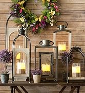 A selection of bright candle lanterns sit on an indoor table creating a warm atmosphere