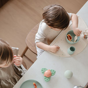 Sibling at snack time using mushie silicone feeding essentials