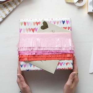 Hallmark birthday gift box decorated with bands of pink, magenta and red tissue paper fringe
