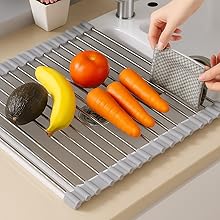 Fresh fruits and vegetables on silicone roll-up drying mat over sink.