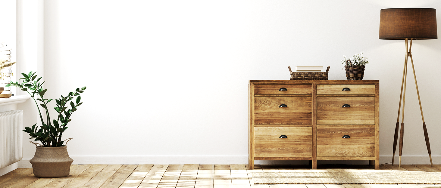 a wooden chest of drawers against a white wall.