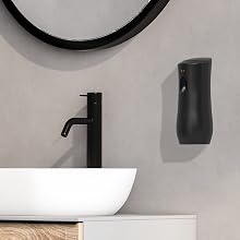 Battery-operated air freshener on bathroom wall near mirror for timed fragrance release.