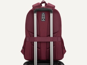 Laptop backpack threaded onto a rolling suitcase handle using the back add-a-bag trolley strap