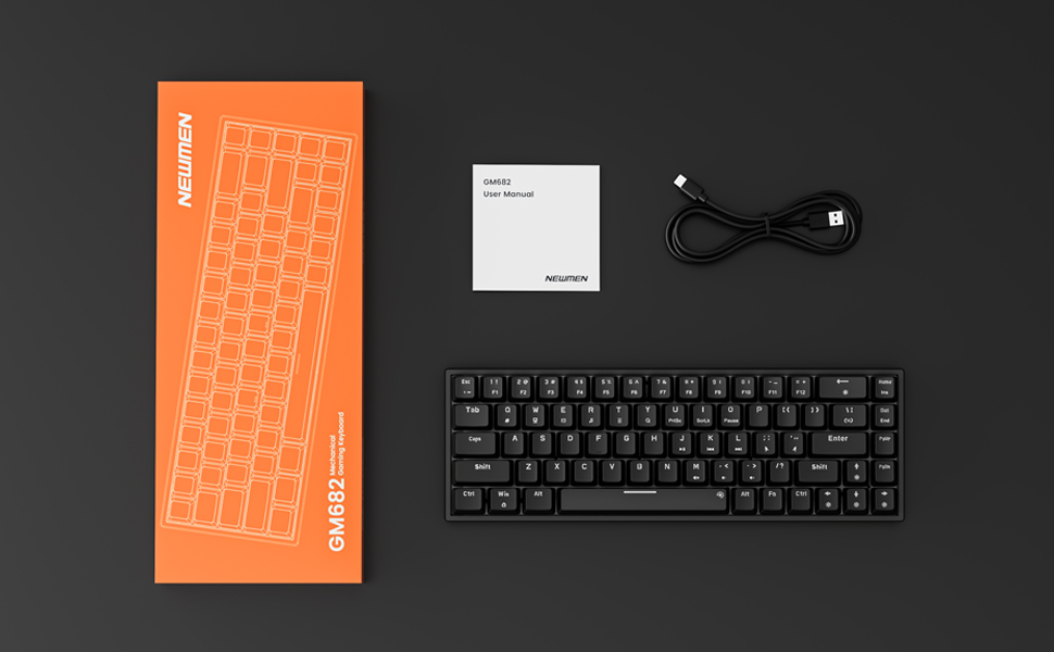 Overhead view of keyboard components: orange wrist rest with dotted pattern, black compact mechanical keyboard, white card, and black USB cable arranged on dark surface.