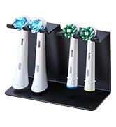 Black desktop organizer stand with multiple vertical slots holding various writing instruments, pens, and markers in different colors including blue, black, white, and green.