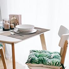 a table with a green cushion and a white bowl on it.