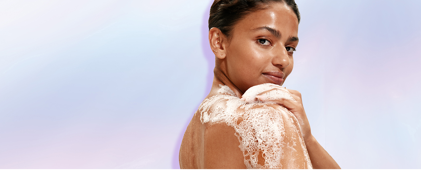 A woman showering with Super Serum Body wash