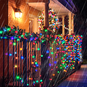 Outdoor holiday decorations with colorful LED string lights wrapped around porch railing and columns, creating festive nighttime display with warm ambient lighting.