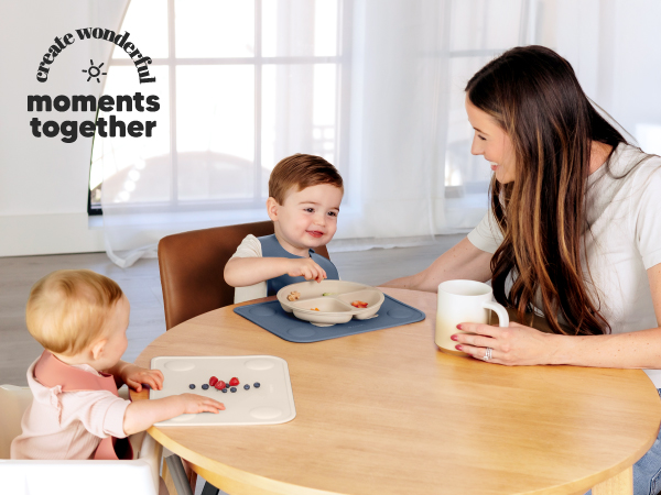 Family enjoying mealtime together with babies using Prep silicone placemats for easy feeding