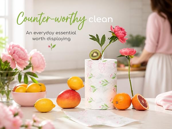 Renova paper towel roll used as a vase accent next to citrus and peonies in a bright kitchen