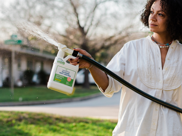 A person spraying Wondercide in their yard