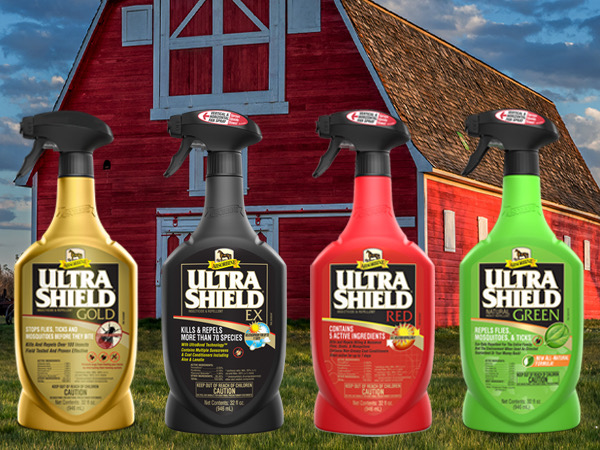 UltraShield bottles of insecticide and repellent in front of a red barn