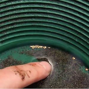 image showing close up of gold flakes caught in gold pan