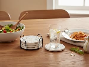 White ceramic coaster set with metal holder on wooden dining table with meal and drinks