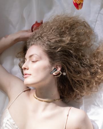 a woman lying on a bed with a headphone in her hand