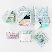 A variety of packed travel pouches and bags in Disney's Aloha Stitch illustration