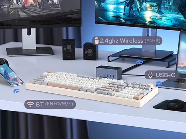 a white desk with a white keyboard and two speakers.
