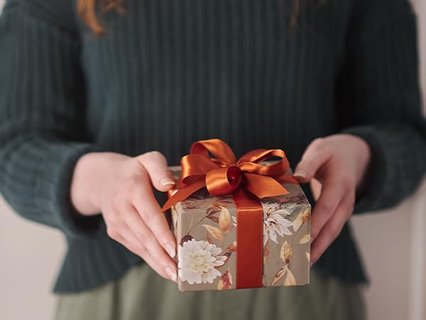 Woman in sweater holding decorative wrapped gift box with ribbon Christian Art Gifts