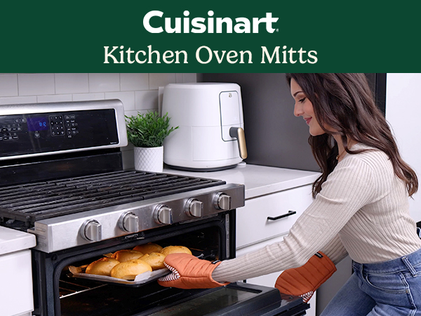 Woman taking hot tray out of oven with oven mitts