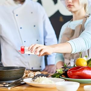 Chef adding salt to dish
