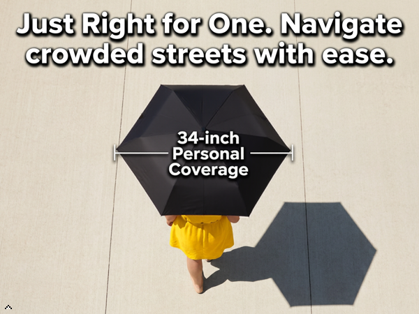 34-inch black umbrella top-down view, person in yellow on tiled pavement with shadow coverage