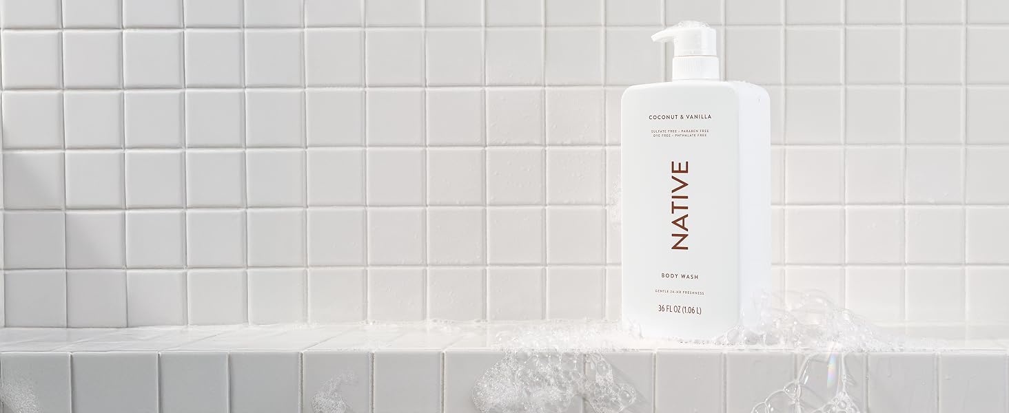 Native's coconut and vanilla sulfate-free bodywash shown in a shower with suds around it